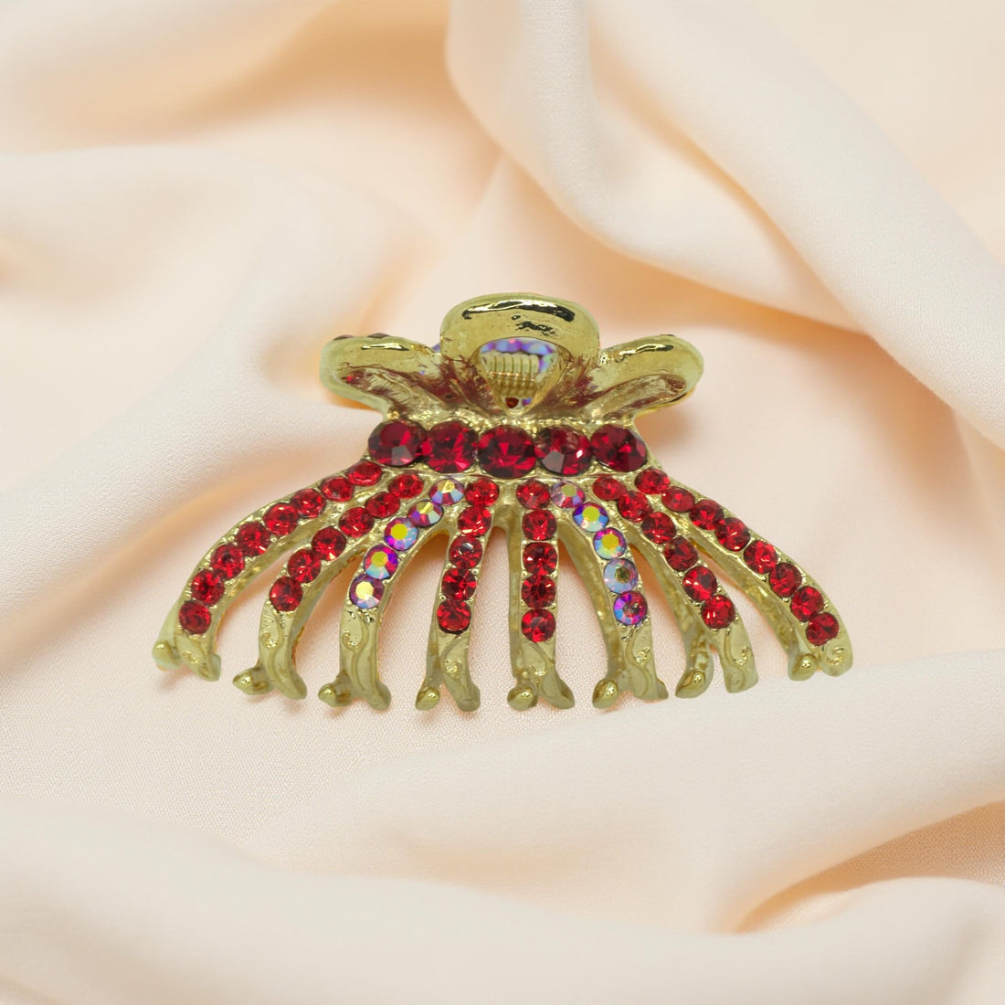 Red crystal detail on Aurefan Arc Claw – vibrant sculpted elegance