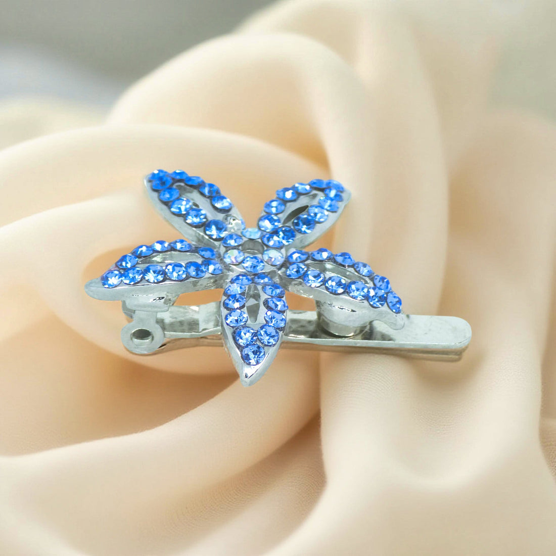 Haerime LilyGleam Clip in Blue – angled view highlighting five-petal pavé crystals and open clasp structure