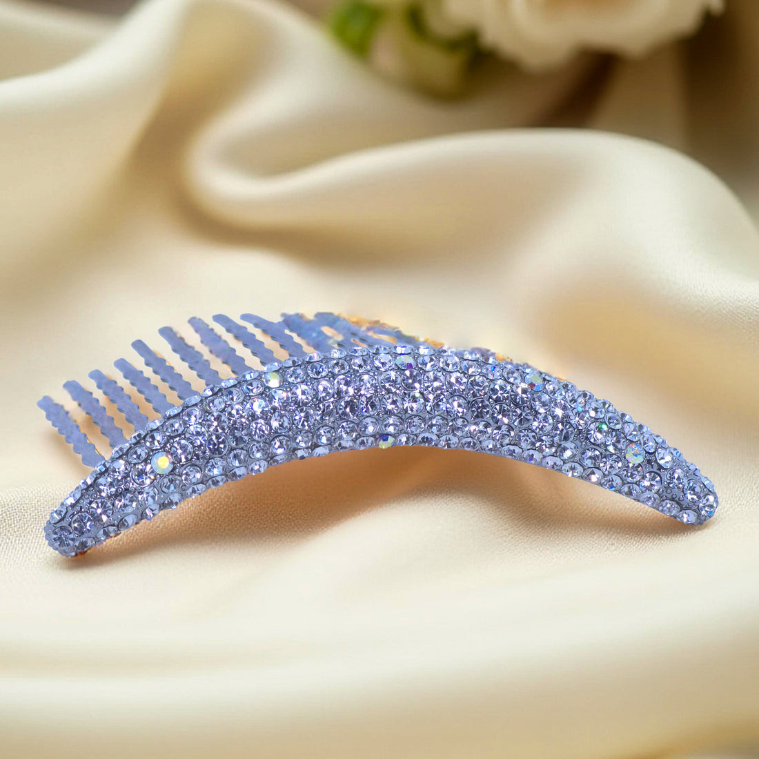 Haerime Lunoria Arch Comb in Clear – close-up of clear crystal arc comb with hand-set pavé on cream satin background