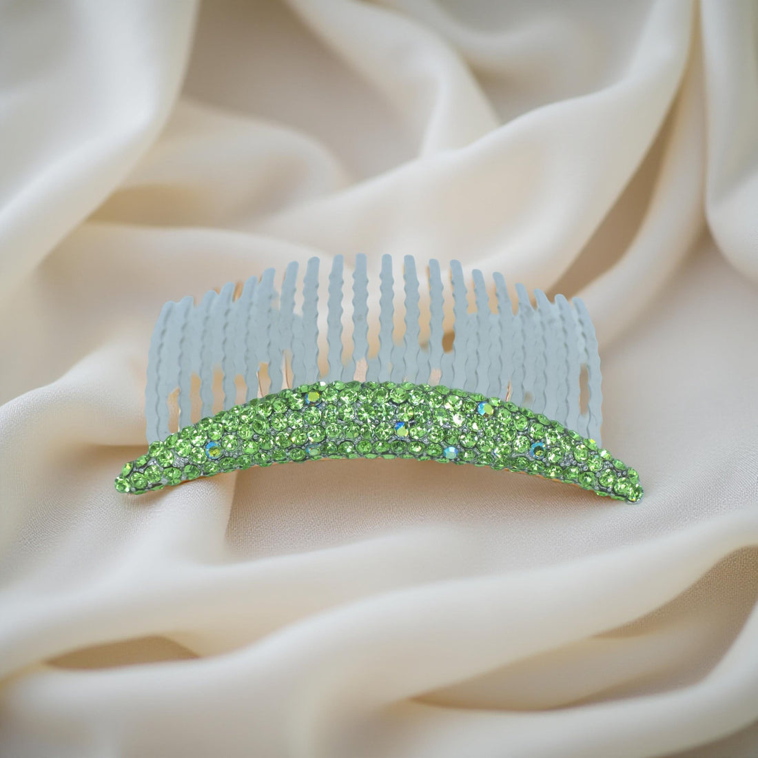 Haerime Lunoria Arch Comb in Peridot – delicate green crystal floral comb laid on cream satin with subtle gold shine