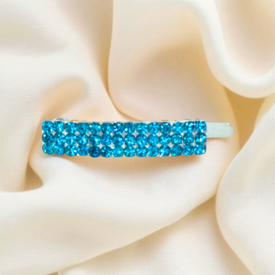 Haerime Magnetta Snap Clip in Blue Zircon – close-up showing teal-toned crystal barrette on cream velvet pouch