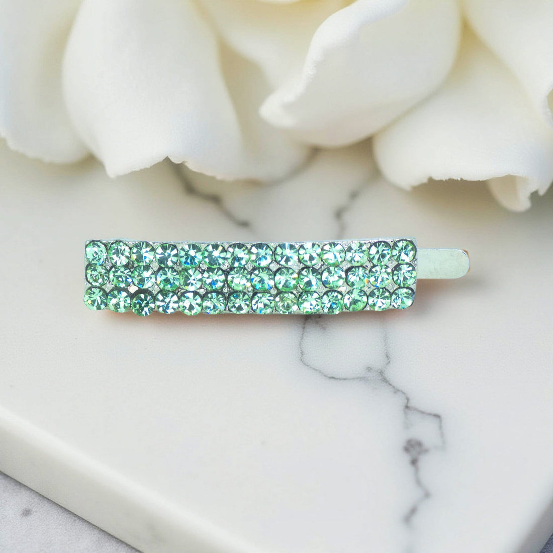 Haerime Magnetta Snap Clip in Peridot – close-up of green pavé stones and seamless clasp system on satin pouch
