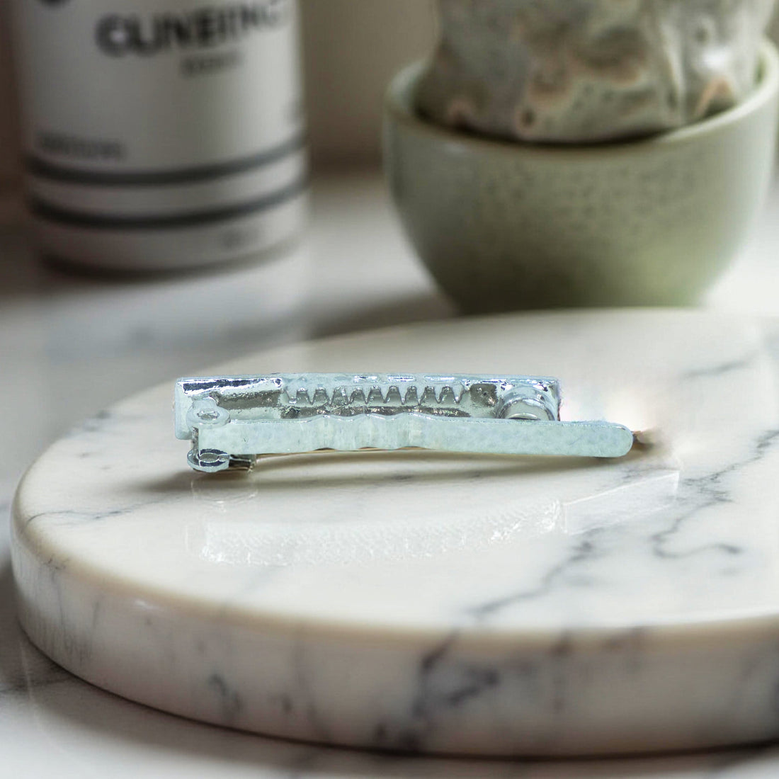 Haerime Magnetta Snap Clip in Peridot – side profile showing curved comb edge and gold-toned base with soft glow