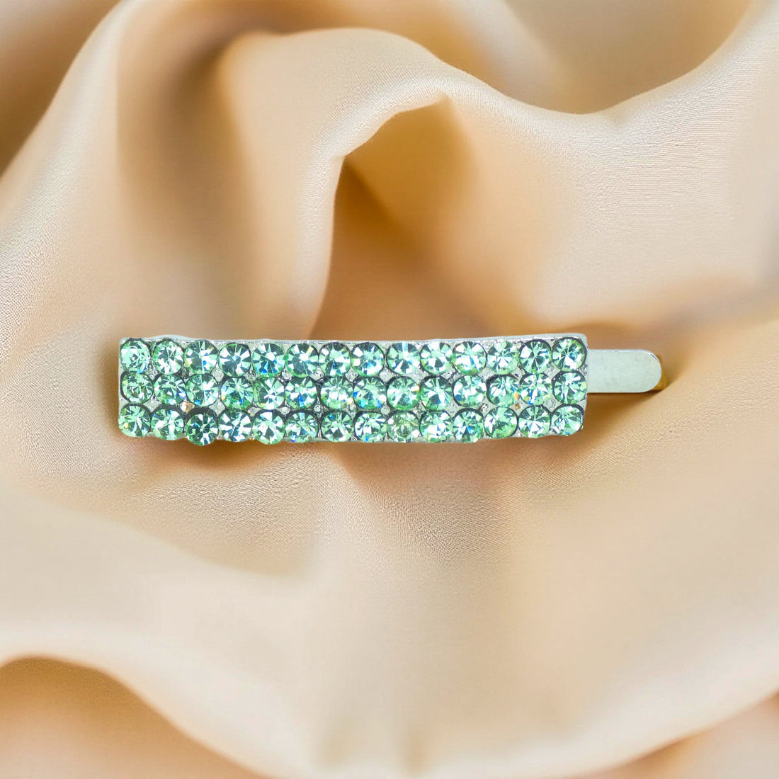 Haerime Magnetta Snap Clip in Peridot – top-down image showing light green pavé bar resting on neutral velvet background