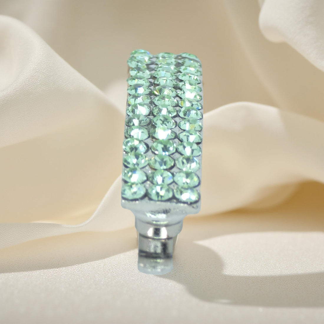 Haerime Magnetta Snap Clip in Peridot – vertical orientation highlighting arc shape and peridot shimmer on pale silk