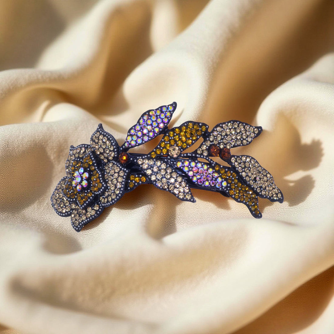 Haerime Midnight Bloom Barrette in Amber – flat lay of golden floral arc with leaf cluster design on pale velvet