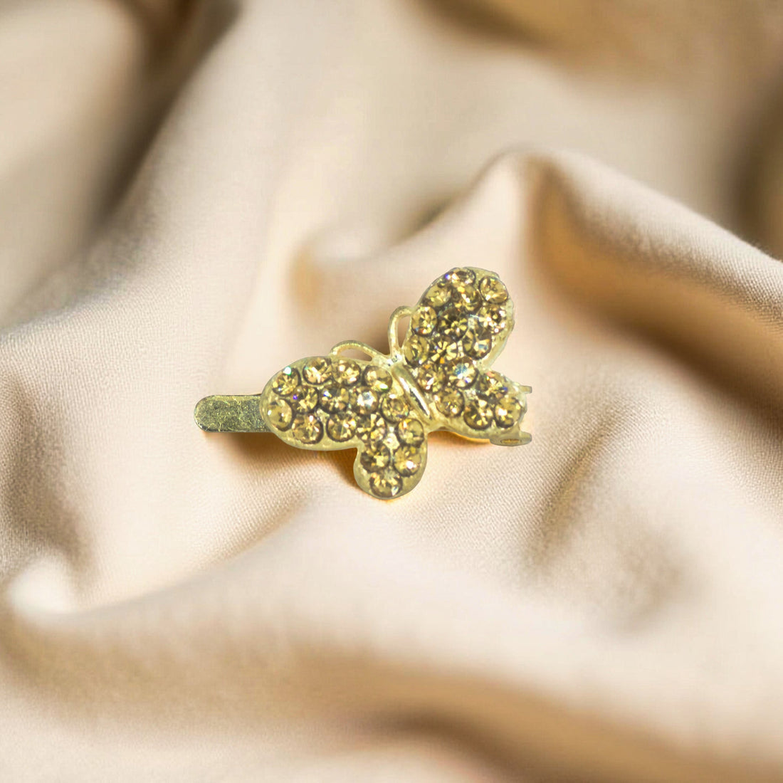 Haerime Papillon Éclat Clip in Amber – close-up of honey crystal butterfly resting on ivory velvet