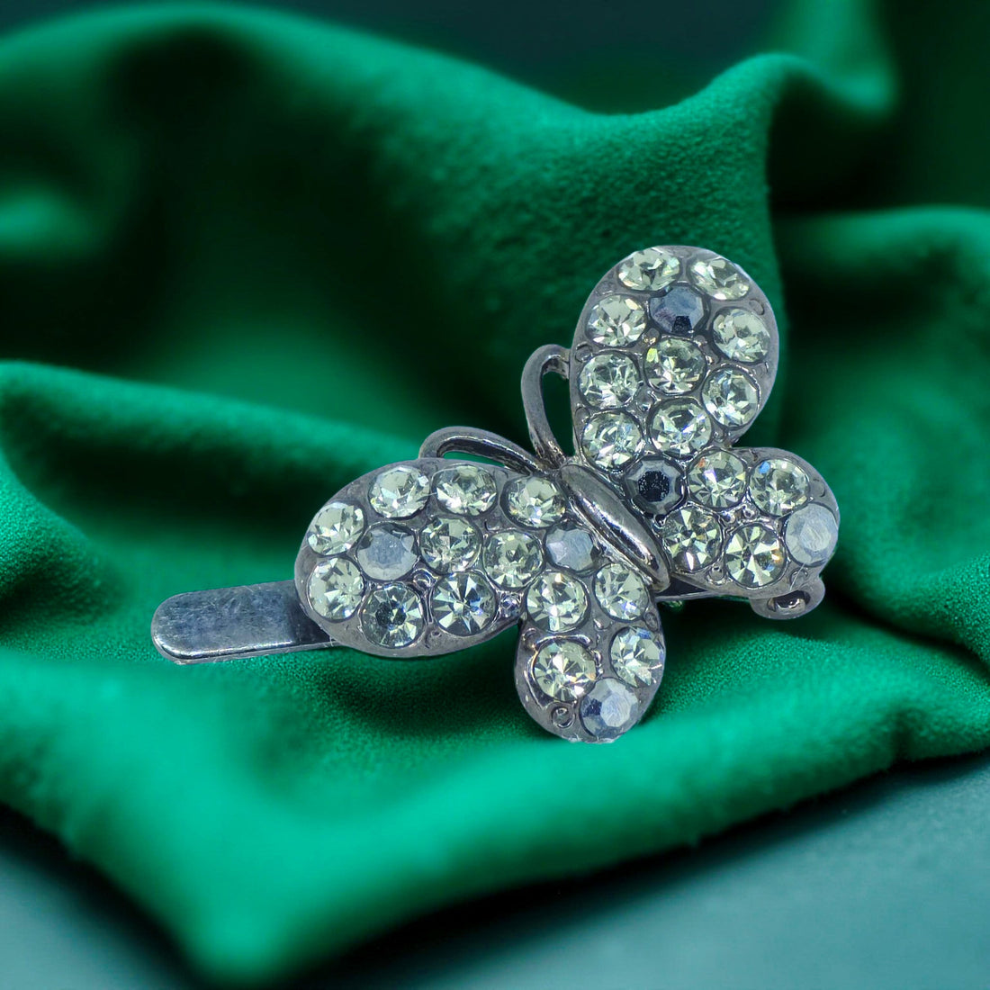 Haerime Papillon Éclat Clip in Black – pavé crystal butterfly silhouette shown on dark velvet surface, emphasizing sculptural symmetry