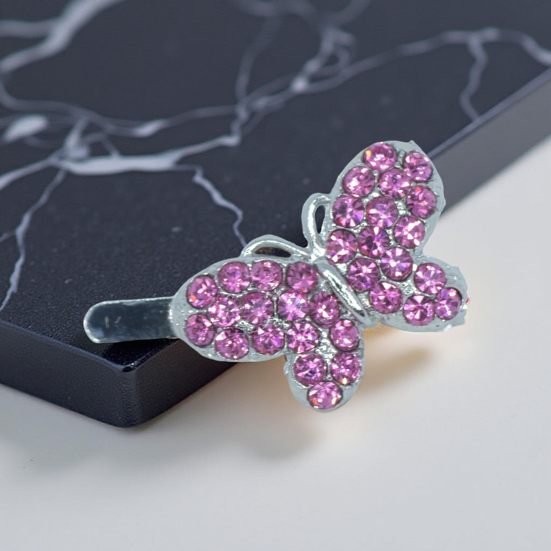 Haerime Papillon Éclat Clip in Pink – blush-toned butterfly clip with rose crystal wings on soft cream background