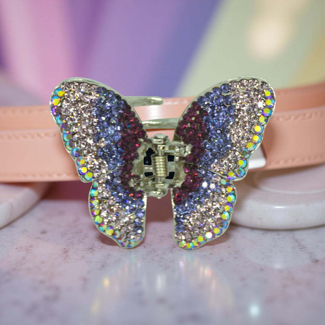 Haerime Papillora Mini Claw in Purple – close-up of lilac pavé-set wings and sculpted shape resting on neutral pink velvet