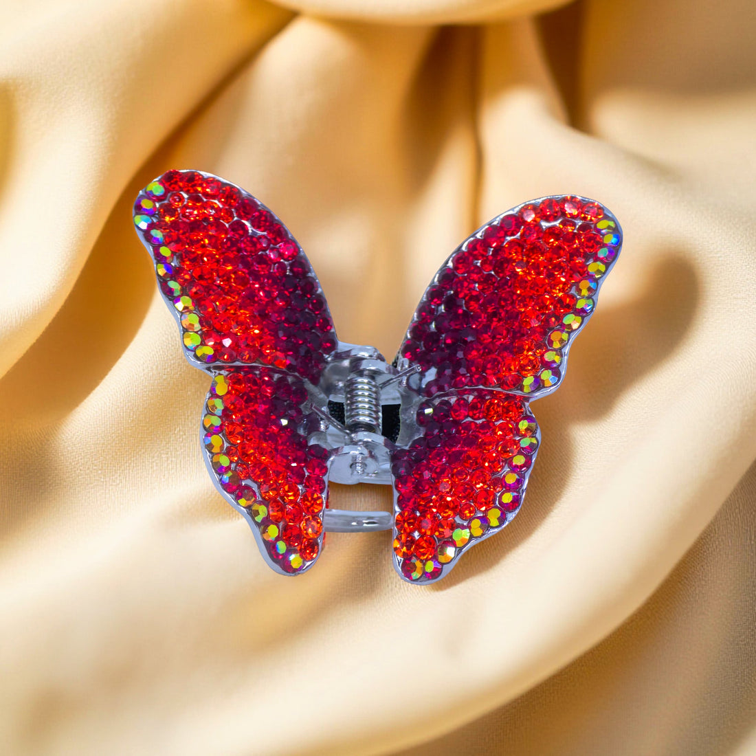 Haerime Papillora Mini Claw in Red – zoomed view of ruby gradient sparkle and silver jaw detail on folded satin pouch