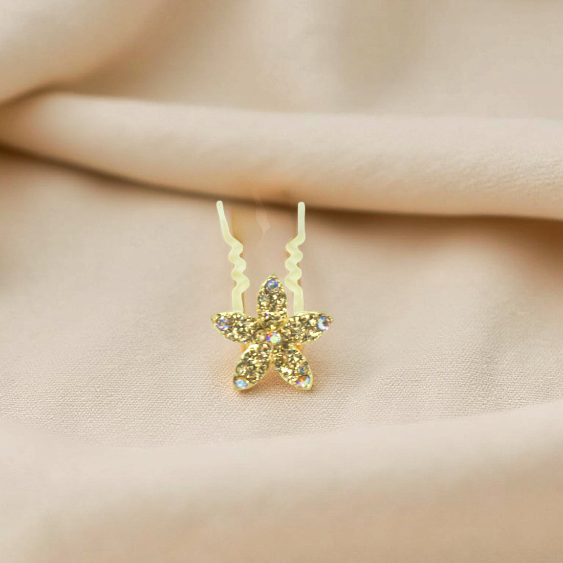 Haerime Petalight Hair Stick in Amber – close-up showing hand-set golden stones on wavy gold pin resting on fabric