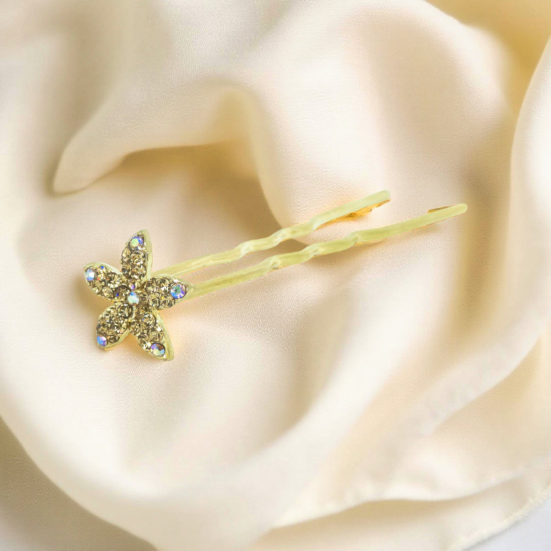 Haerime Petalight Hair Stick in Amber – top view of amber pavé petals placed on soft cream velvet