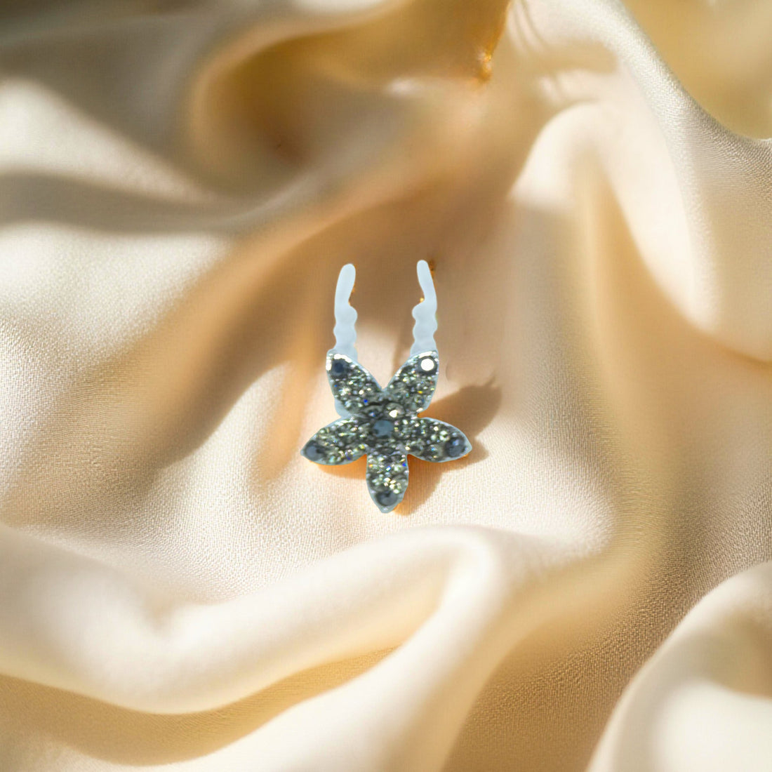 Haerime Petalight Hair Stick in Black – close-up showing dark pavé petals and silver-tone pin on neutral fabric pouch