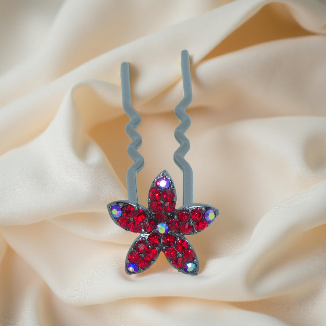 Haerime Petalight Hair Stick in Red – top-down view of crimson flower pin displayed on soft ivory fabric