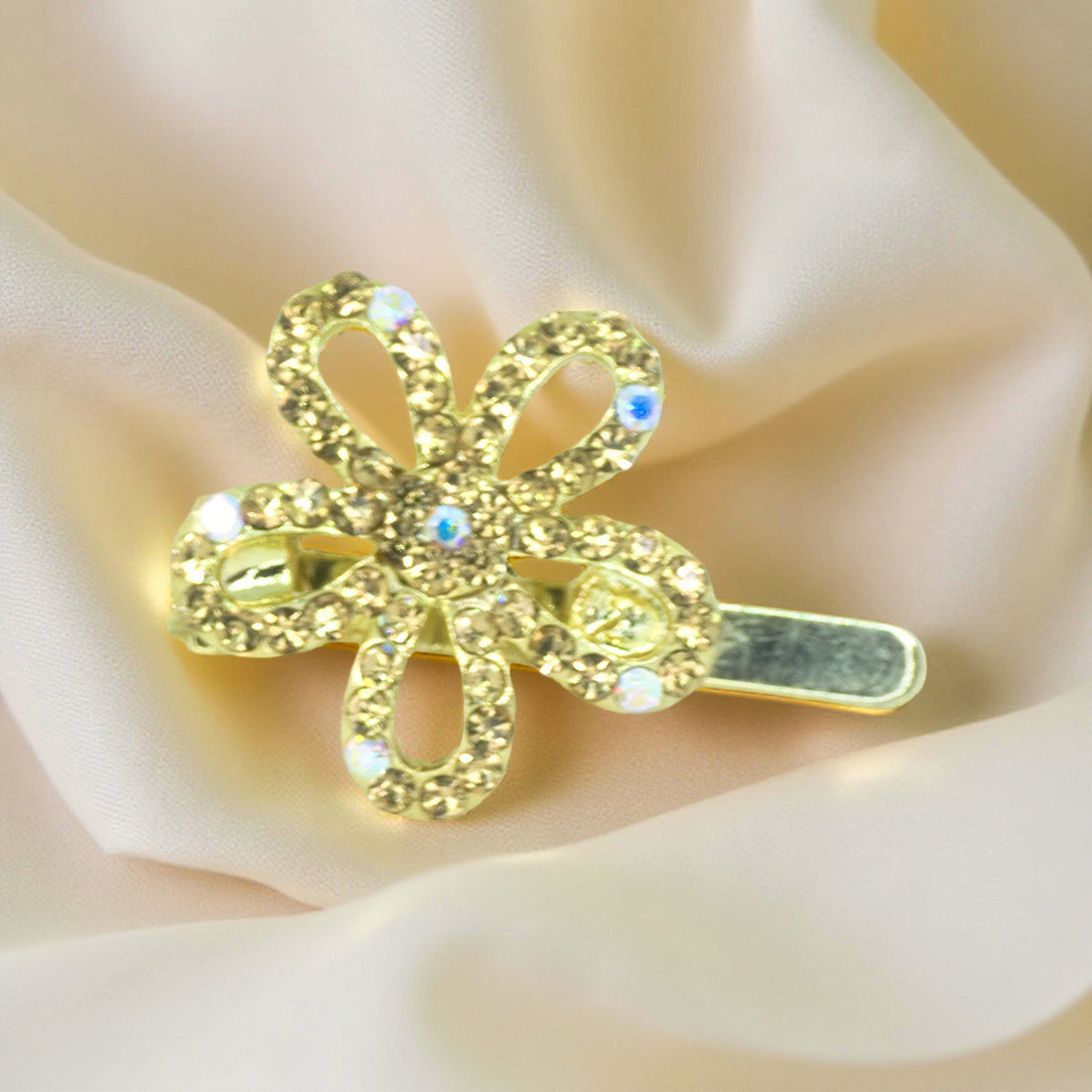 Haerime PetalMuse Magnetique in Amber – warm golden floral clip with honey crystals placed on peach-toned satin