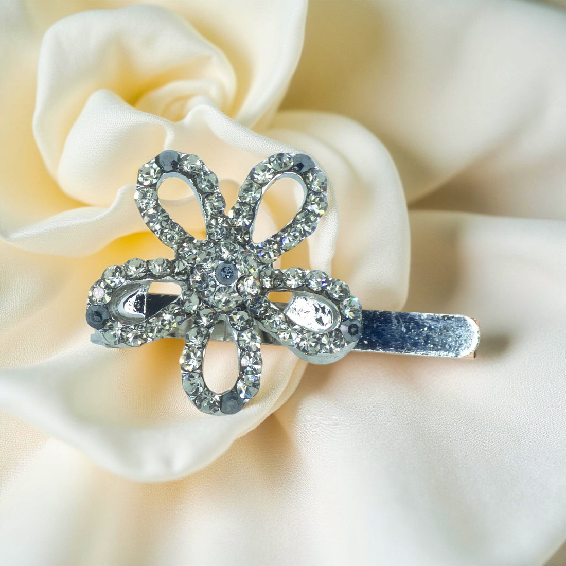 Haerime PetalMuse Magnetique in Black – jet crystal mini flower clip on cream satin with soft shadow transitions