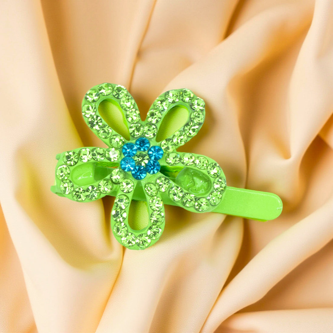 Haerime PetalMuse Magnetique in Peridot – five-petal green bloom resting on champagne satin under warm ambient light