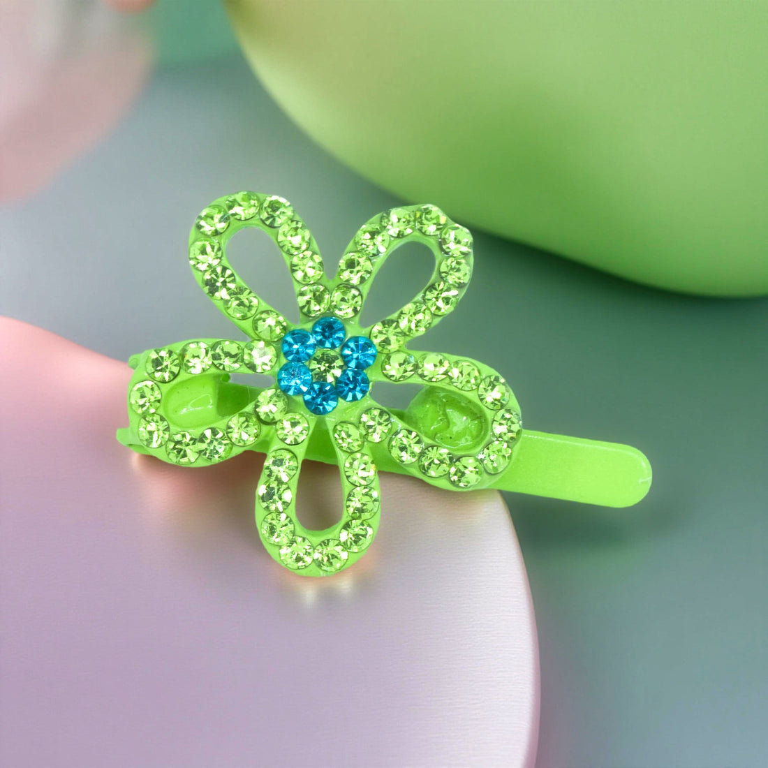 Haerime PetalMuse Magnetique in Peridot – lime-green floral clip with crystal shimmer placed on beige velvet in soft light