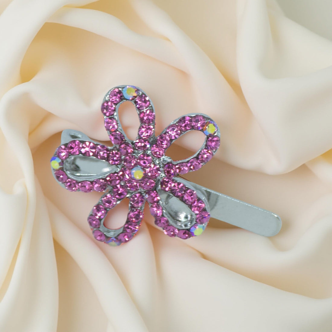 Haerime PetalMuse Magnetique in Pink – soft rose pavé mini bloom clip resting on folded ivory satin background