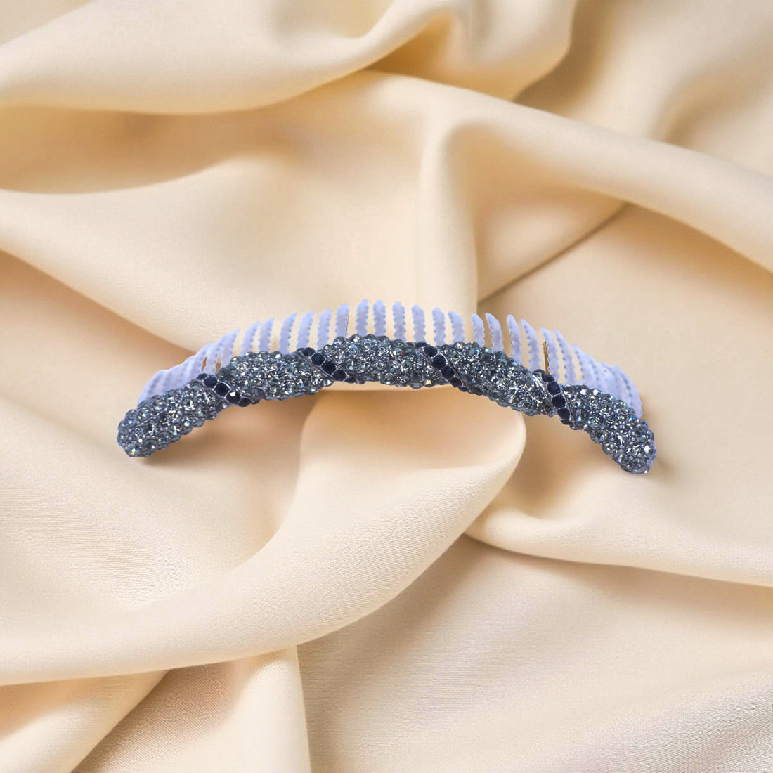 Haerime Seraphine Twist Comb in Black – black pavé ribbon arc comb shown on ivory silk with muted glow