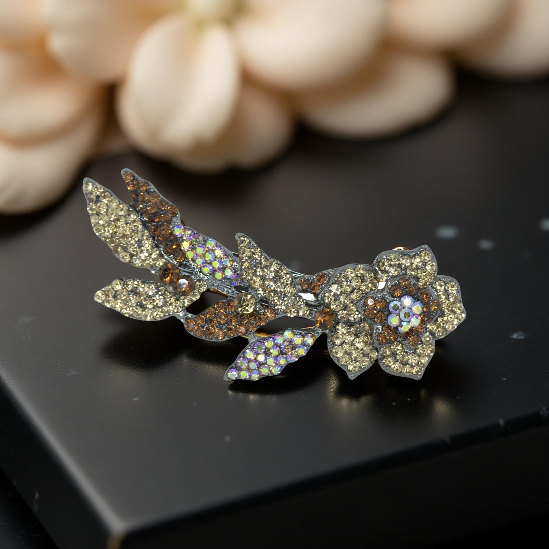 Haerime Twilight Bloom Mini in Amber – golden crystal barrette shown on beige velvet under directional soft lighting