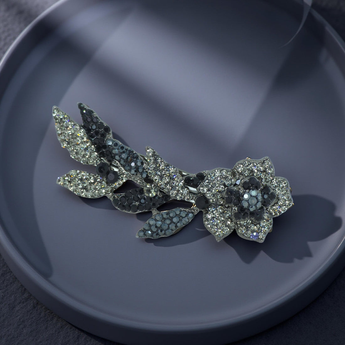 Haerime Twilight Bloom Mini in Black – jet floral comb shown on matte beige satin with subtle reflection