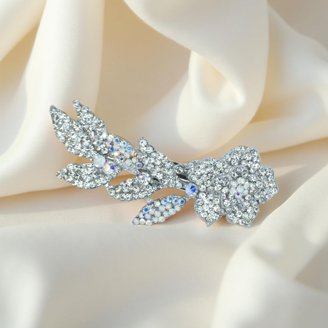 Haerime Twilight Bloom Mini in Clear – clear pavé floral barrette resting on champagne satin with soft morning glow