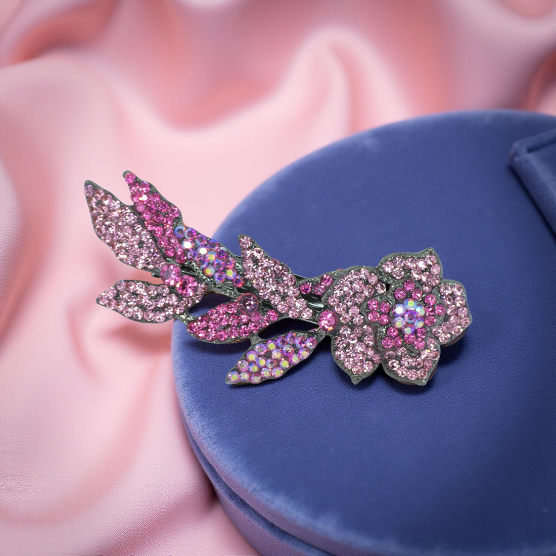 Haerime Twilight Bloom Mini in Pink – top view of pastel pink floral barrette resting on blush satin folds