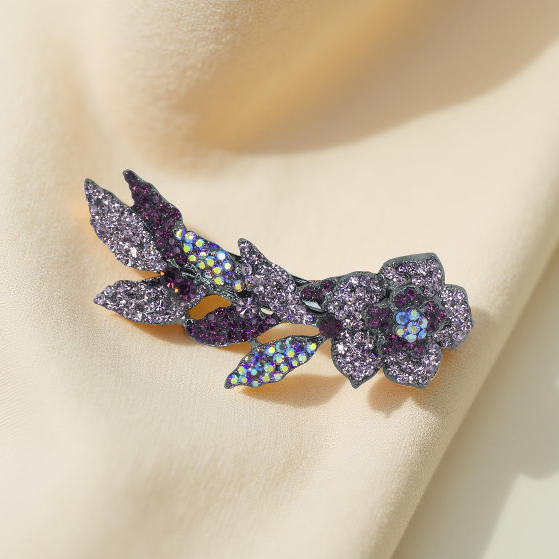 Haerime Twilight Bloom Mini in Purple – lavender crystal floral arc placed on pale silk pouch with silver tone reflection