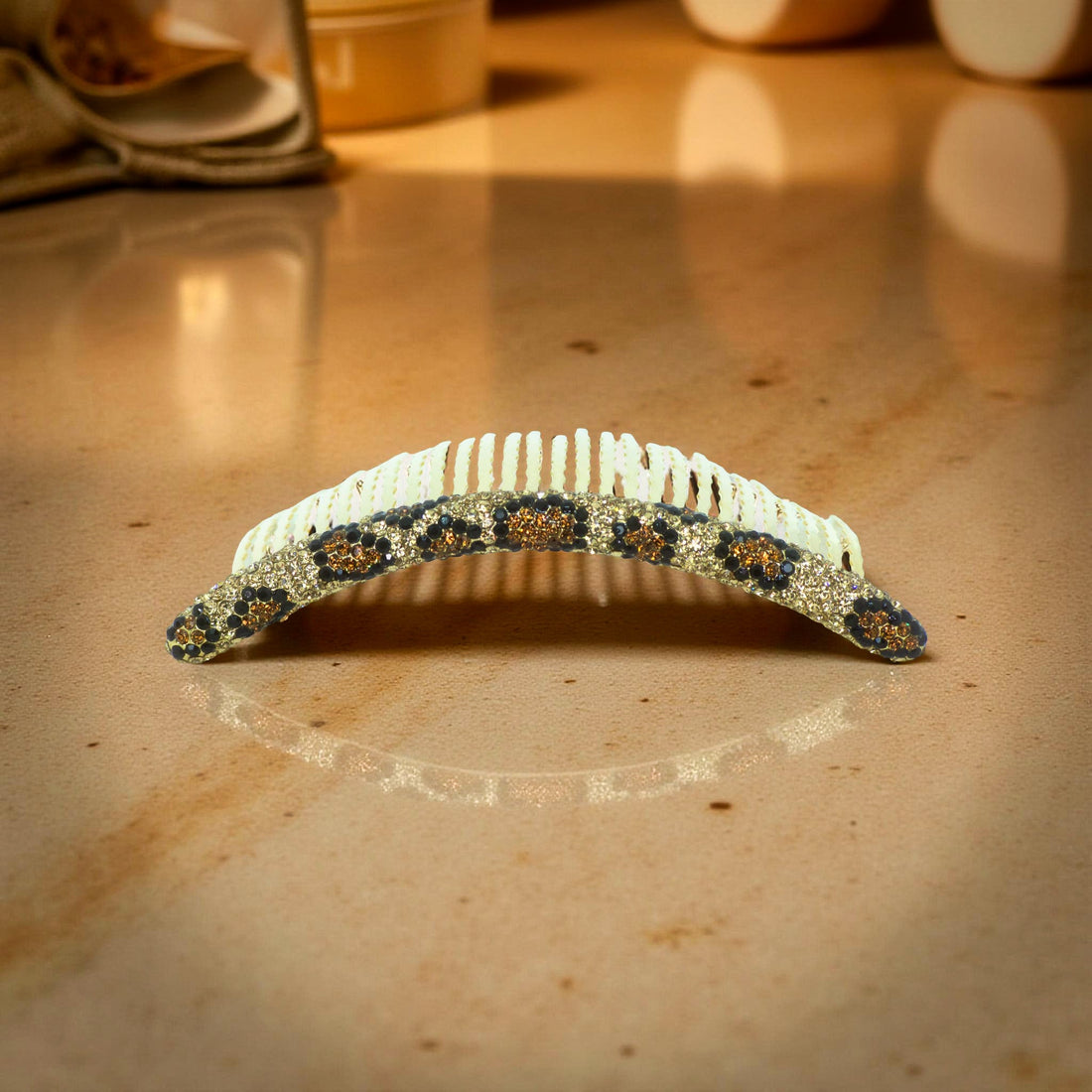Haerime Velvette Arc in Golden Leopard – top view of long crystal comb with gold animal pattern placed on champagne satin