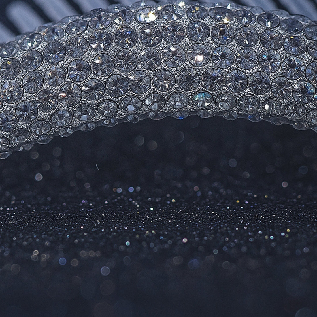 Haerime Lunoria Arch Comb in Black – macro shot capturing full crystal coverage and fine silver prongs, placed on dark acrylic plate