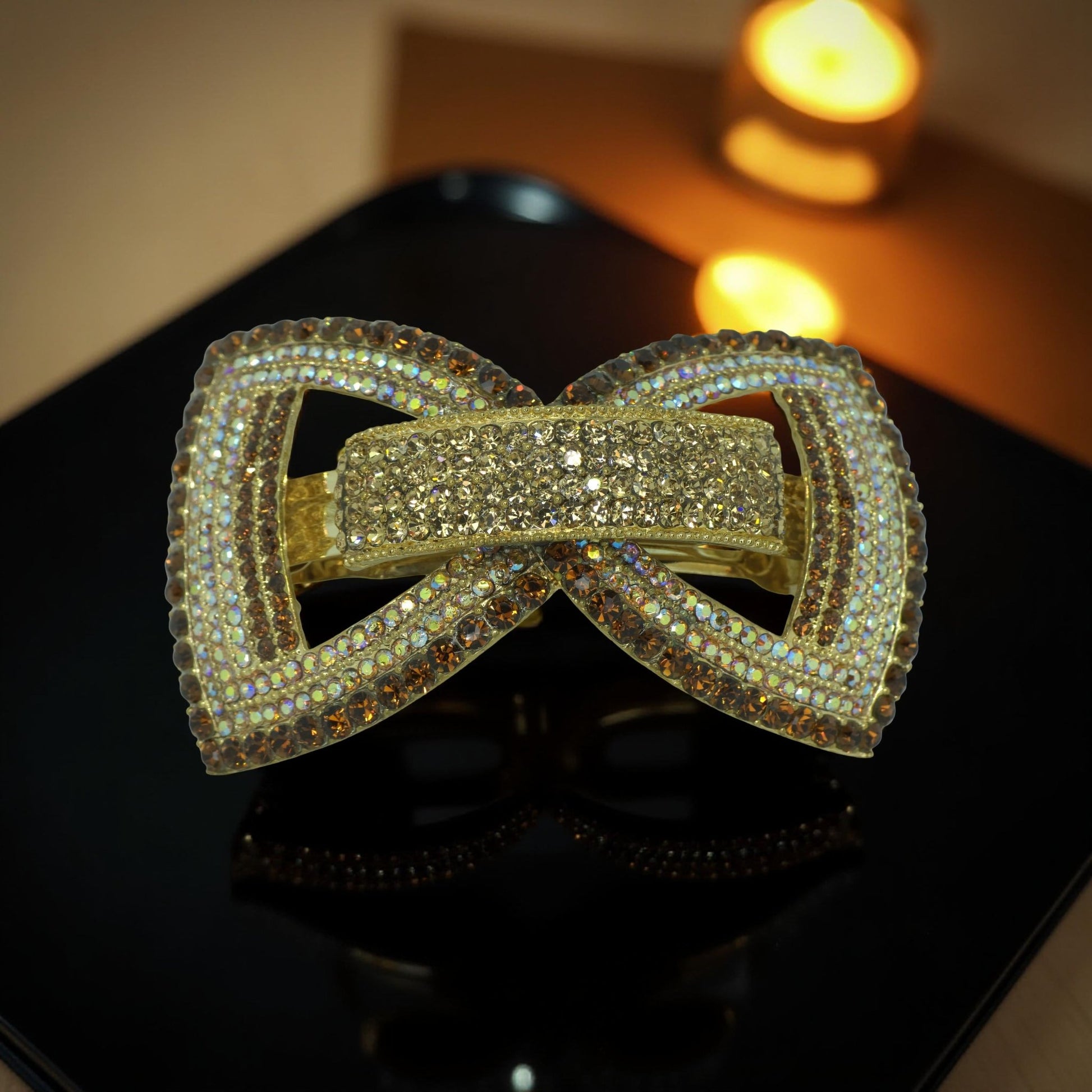 Haerime Ecliptique Bow in Amber close-up – golden rhinestones with sculpted detail and gloss enamel