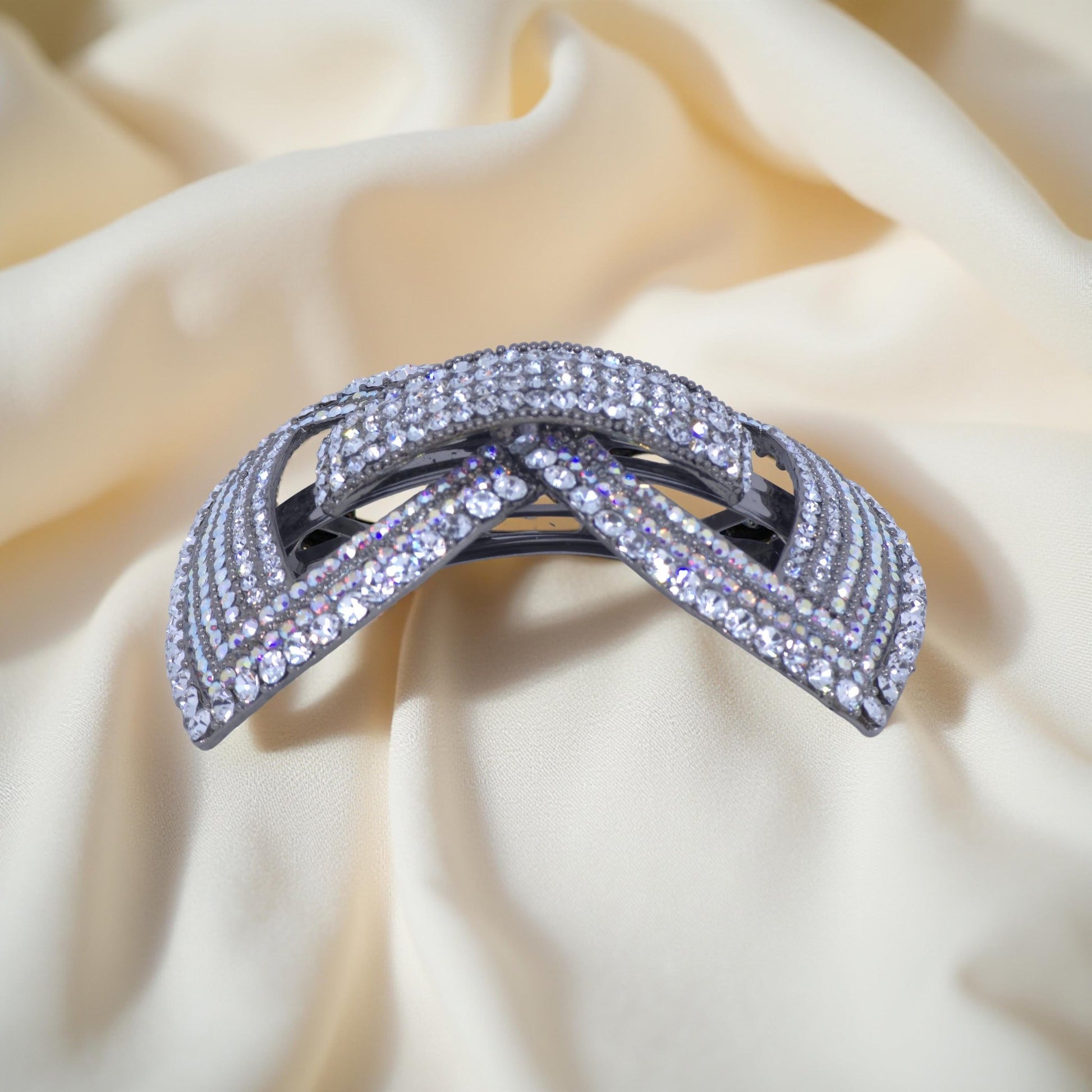 Horizontal side view of Haerime Ecliptique Bow in Clear – sculpted arc with layered crystals on soft-textured surface