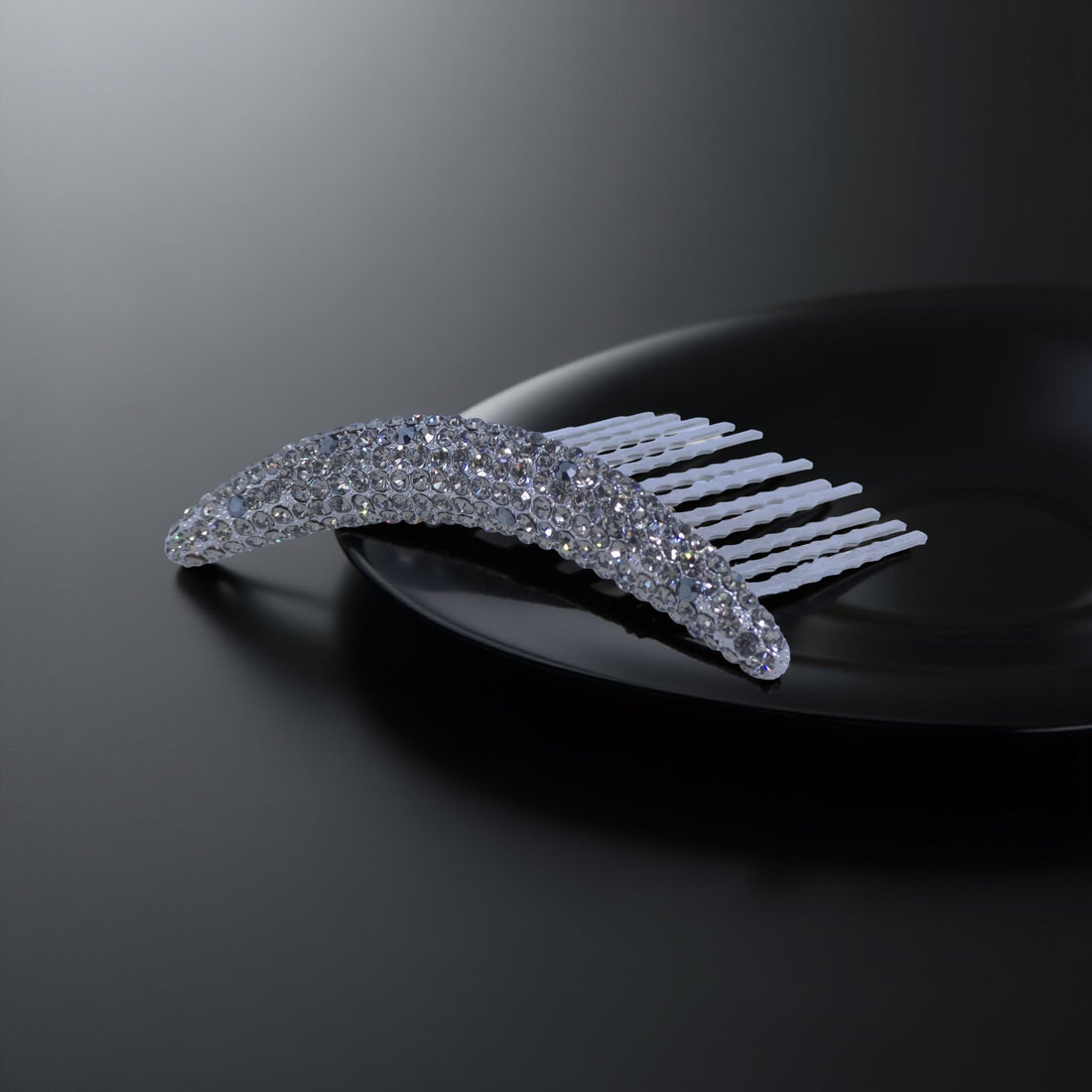 Haerime Lunoria Arch Comb in Black – crystal pavé crescent comb with arc silhouette, displayed on glossy black surface under spotlight