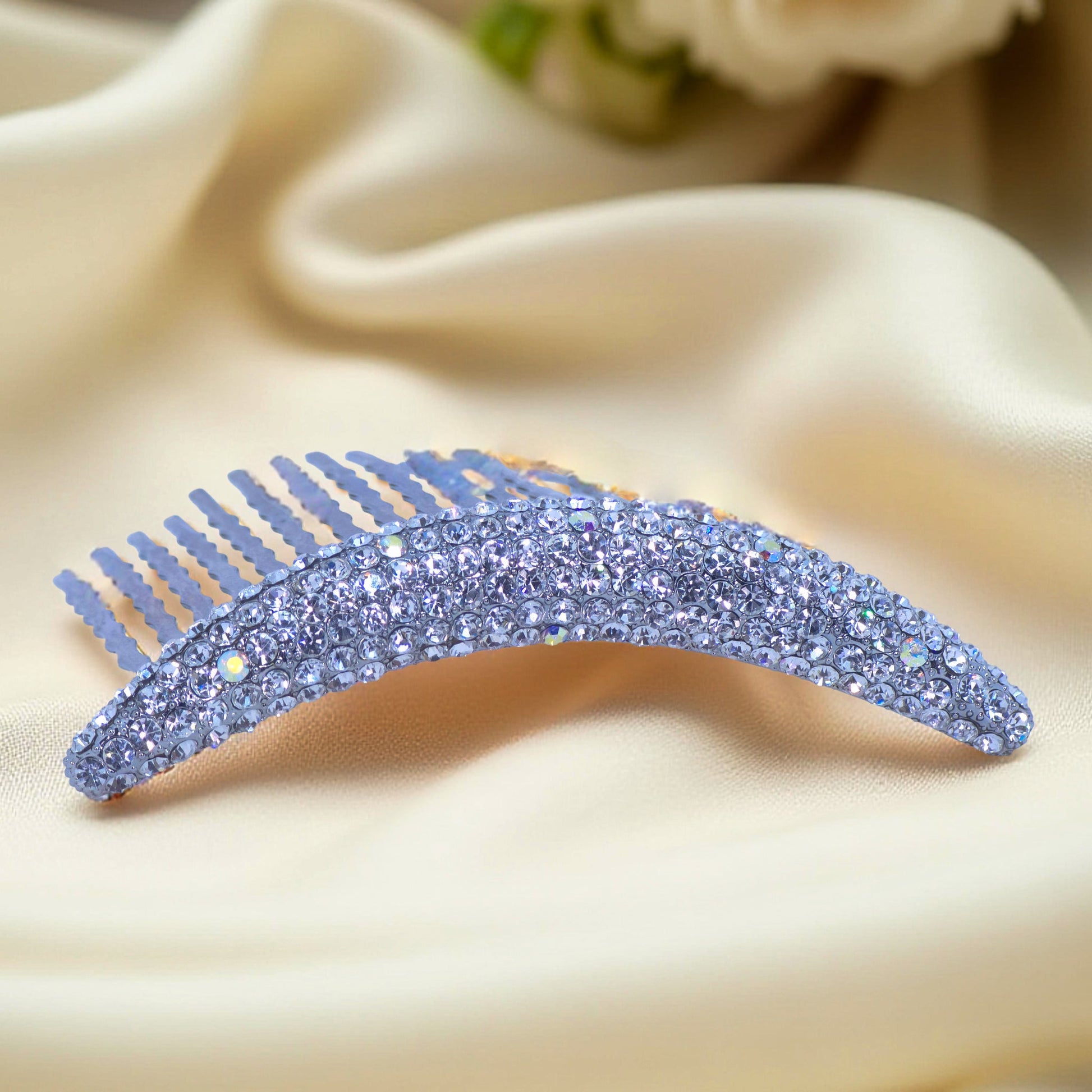 Haerime Lunoria Arch Comb in Clear – close-up of clear crystal arc comb with hand-set pavé on cream satin background