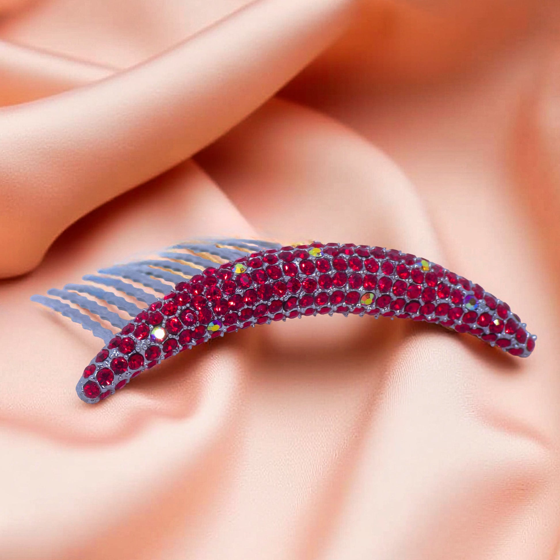 Haerime Lunoria Arch Comb in Red – detailed shot of ruby-tone crystals and wave-etched teeth on silver base