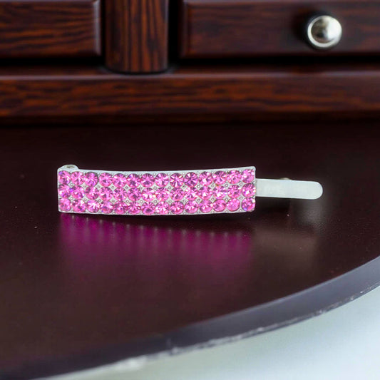 Haerime Magnetta Snap Clip in Pink – curved crystal barrette with dual-row blush stones, shown on white velvet surface under soft light
