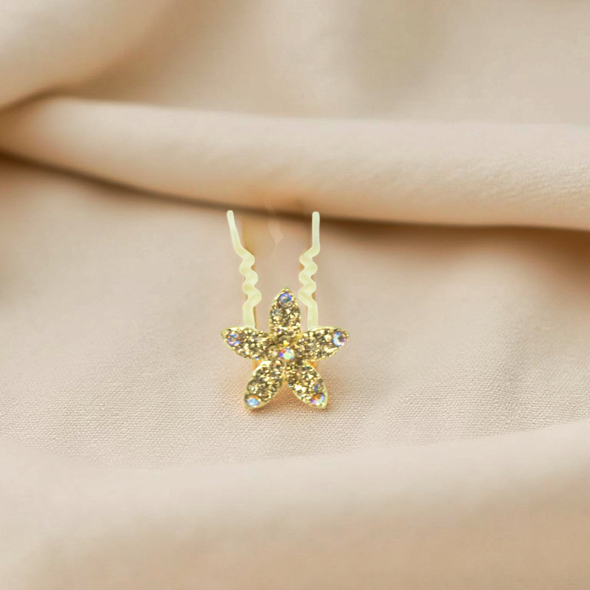 Haerime Petalight Hair Stick in Amber – close-up showing hand-set golden stones on wavy gold pin resting on fabric