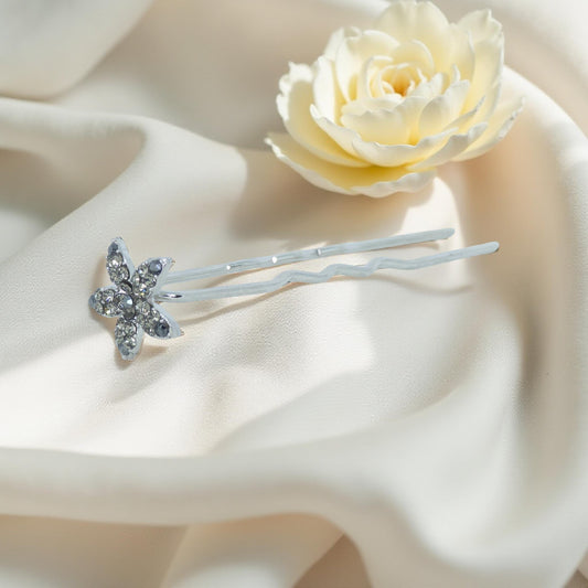 Haerime Petalight Hair Stick in Black – crystal blossom pin with jet petals placed on matte ivory satin in soft natural light