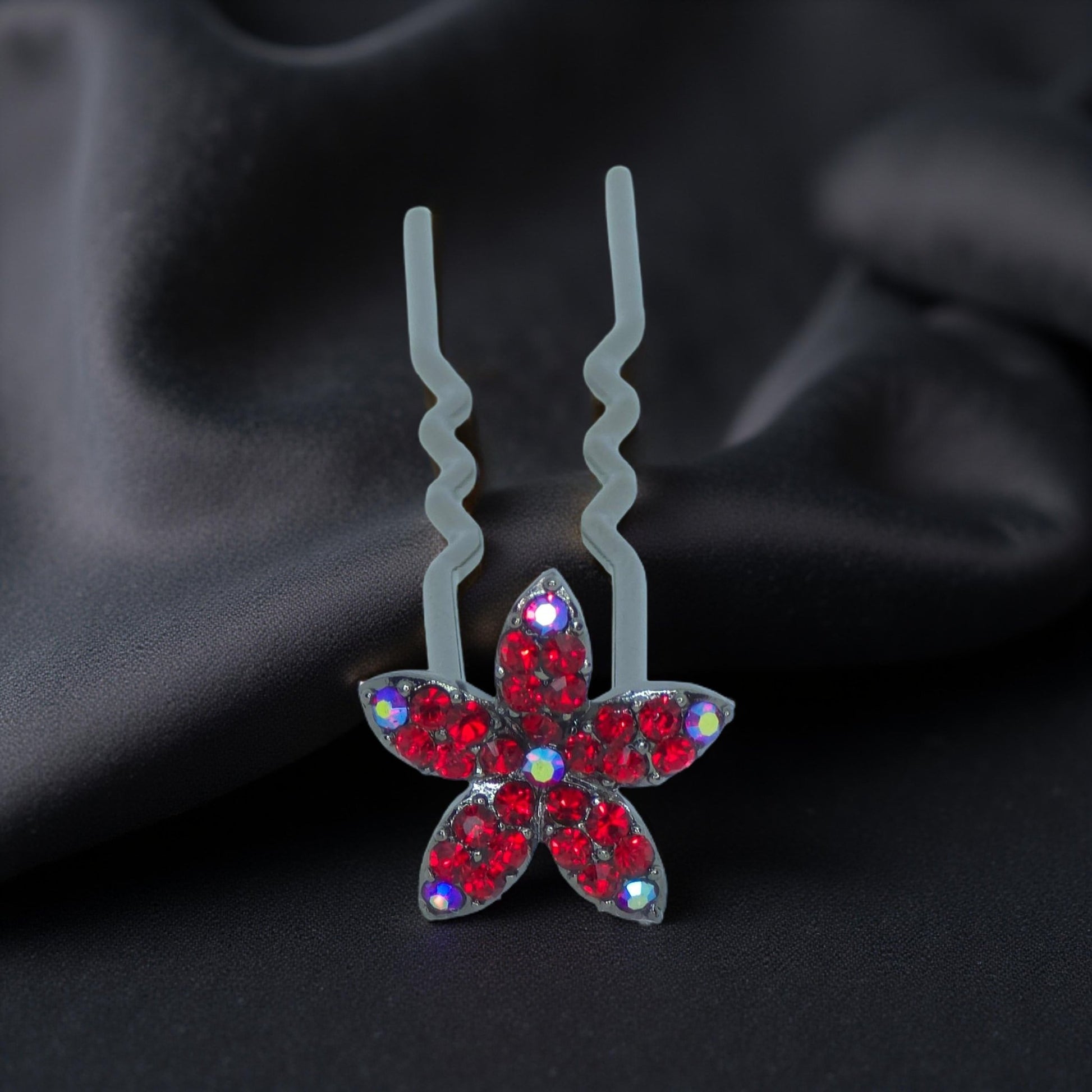 Haerime Petalight Hair Stick in Red – close-up capturing red pavé petals and smooth pin shape on pale satin