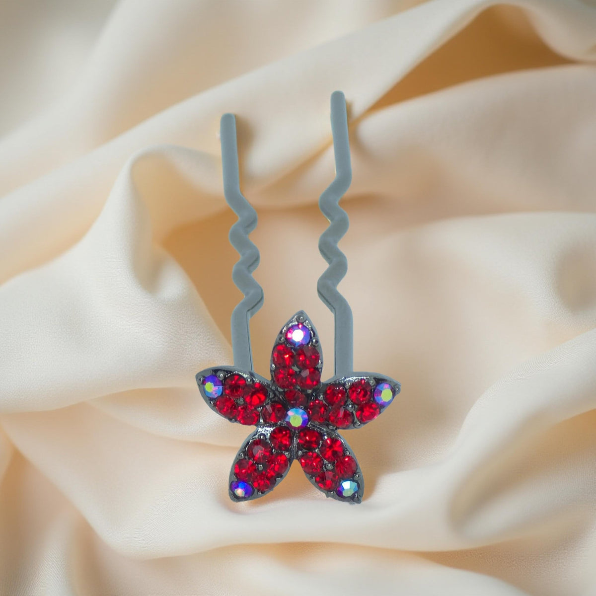 Haerime Petalight Hair Stick in Red – top-down view of crimson flower pin displayed on soft ivory fabric