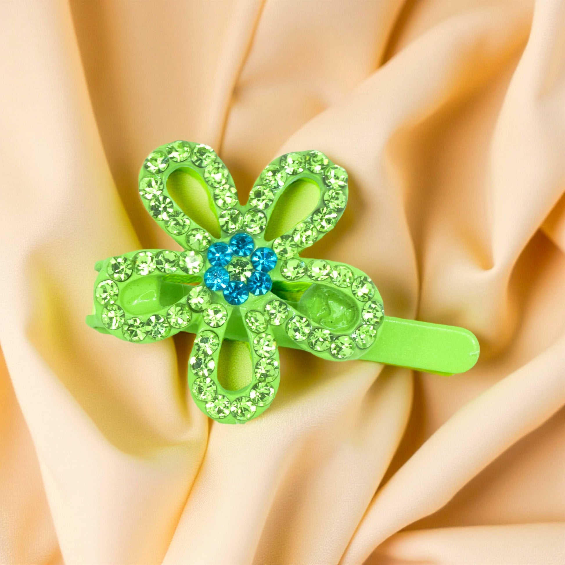Haerime PetalMuse Magnetique in Peridot – five-petal green bloom resting on champagne satin under warm ambient light