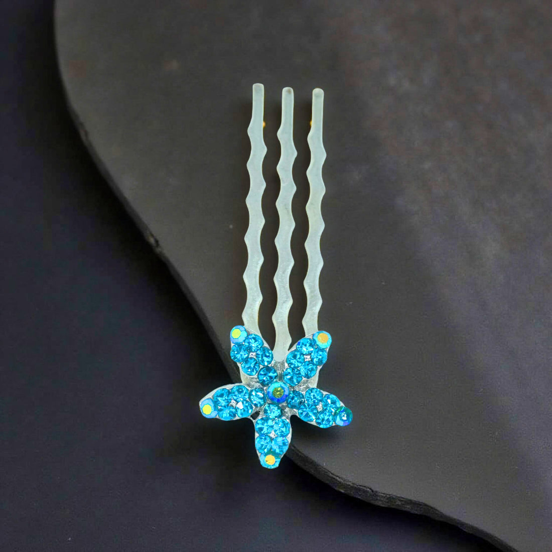 Haerime Starpetal Minis in Blue Zircon – aquamarine crystal flower pin displayed on cool ivory satin under diffused lighting