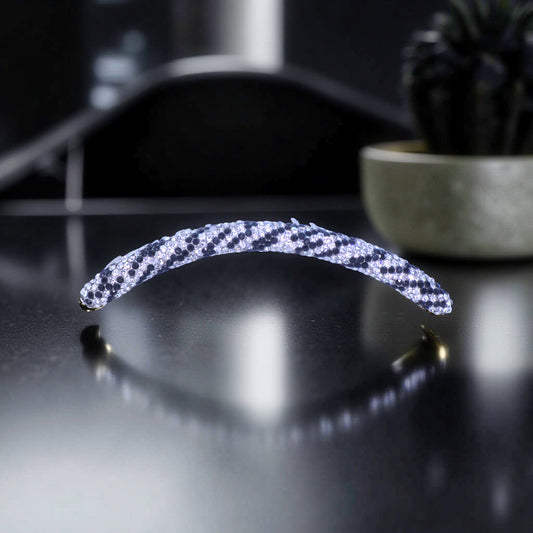 Haerime Velvette Arc in Ice Panther – long crystal arc comb with black and silver animal pattern resting on matte stone counter in studio light